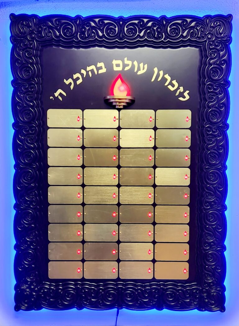 לוח הנצחה עם בסיס בגוון עץ, לוחיות זהובות ולהבה מרכזית